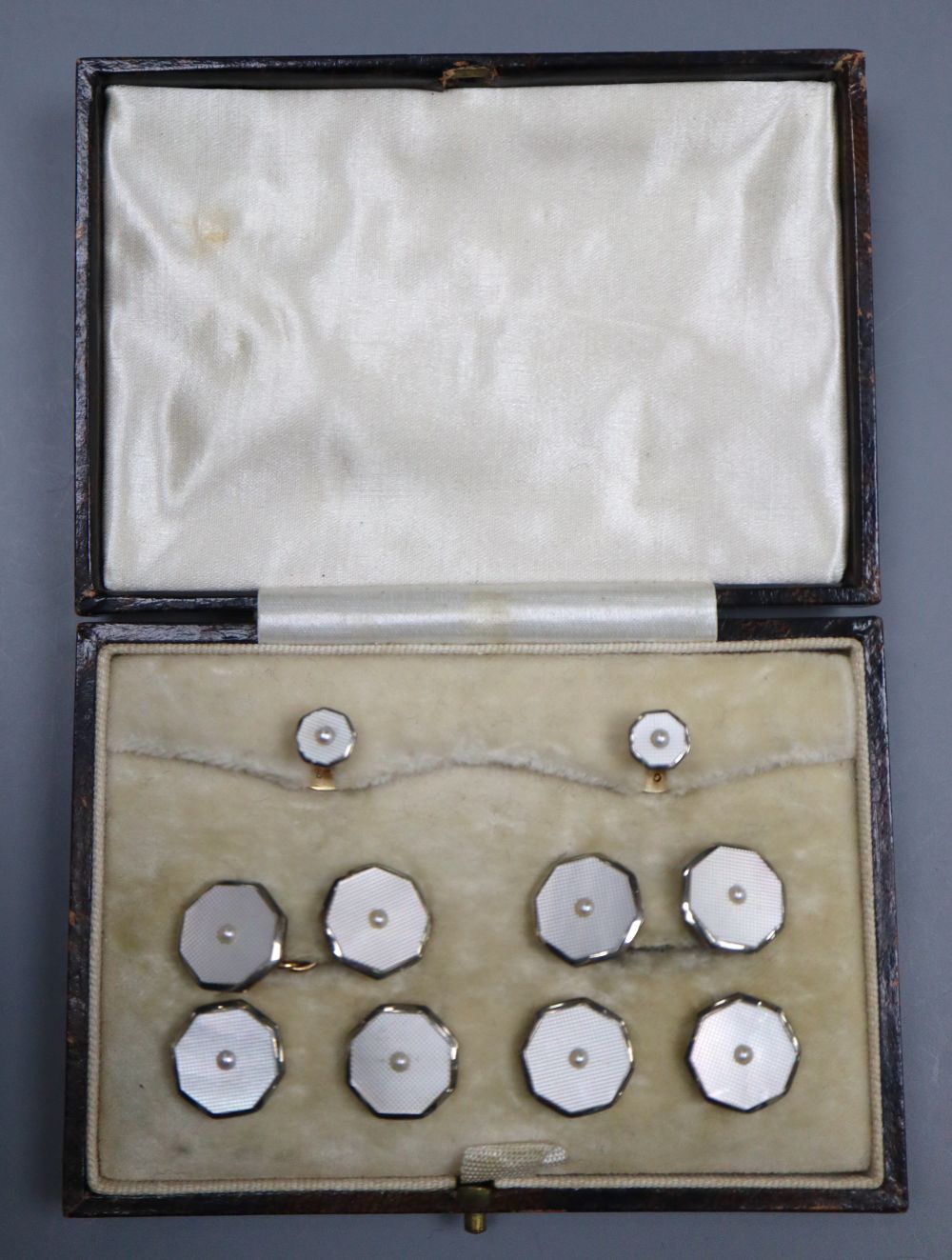 A cased mid 20th century 9ct & 18ct, mother of pearl and seed pearl set eight piece octagonal dress stud set, gross 12.5 grams.